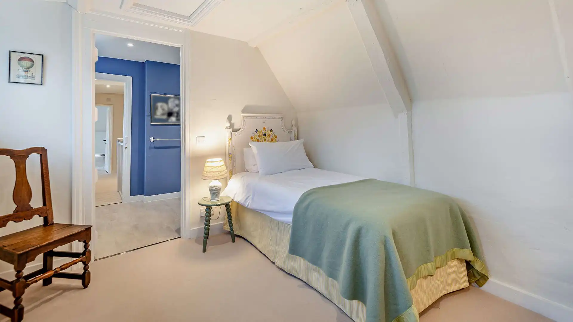 Perfect for younger guests, this single bedroom has a delicately painted headboard and chest of drawers