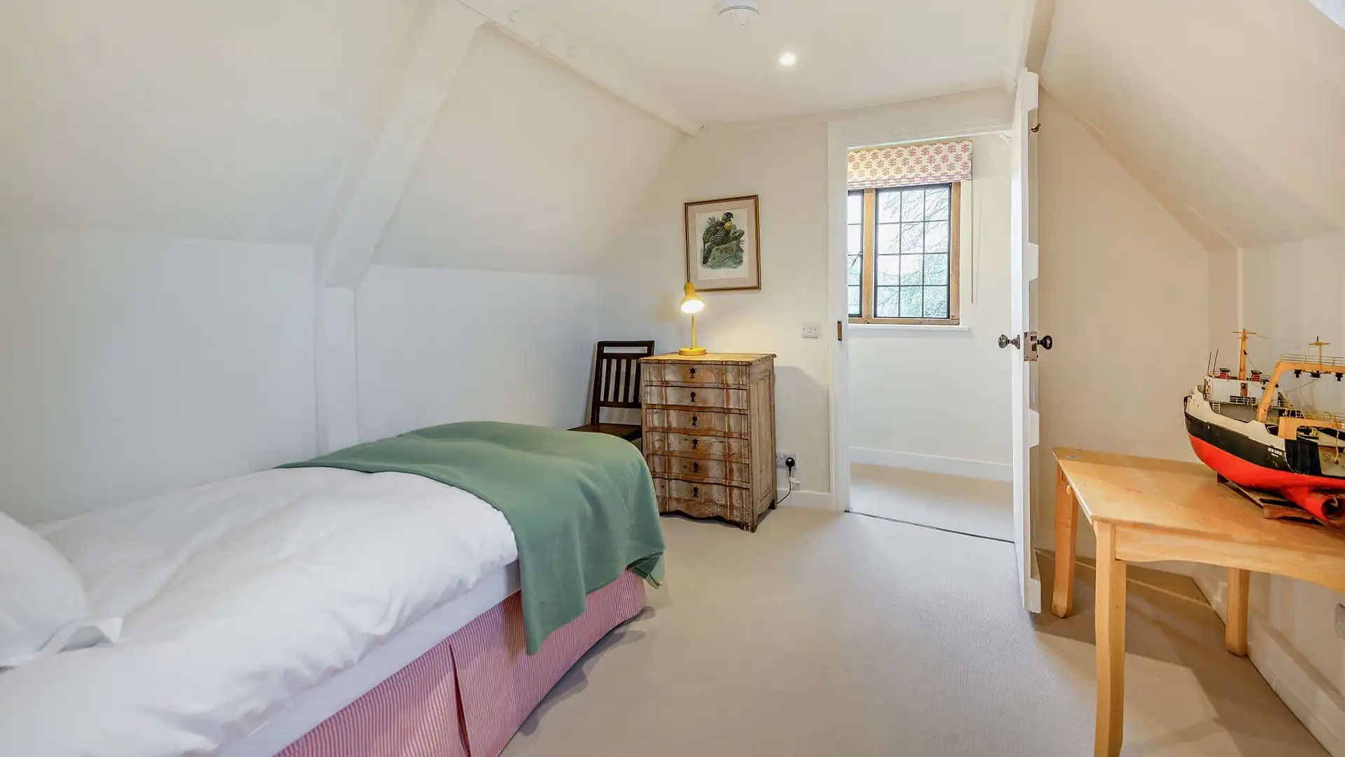 With a single bed tucked into the corner, the final bedroom looks out over the surrounding fields 