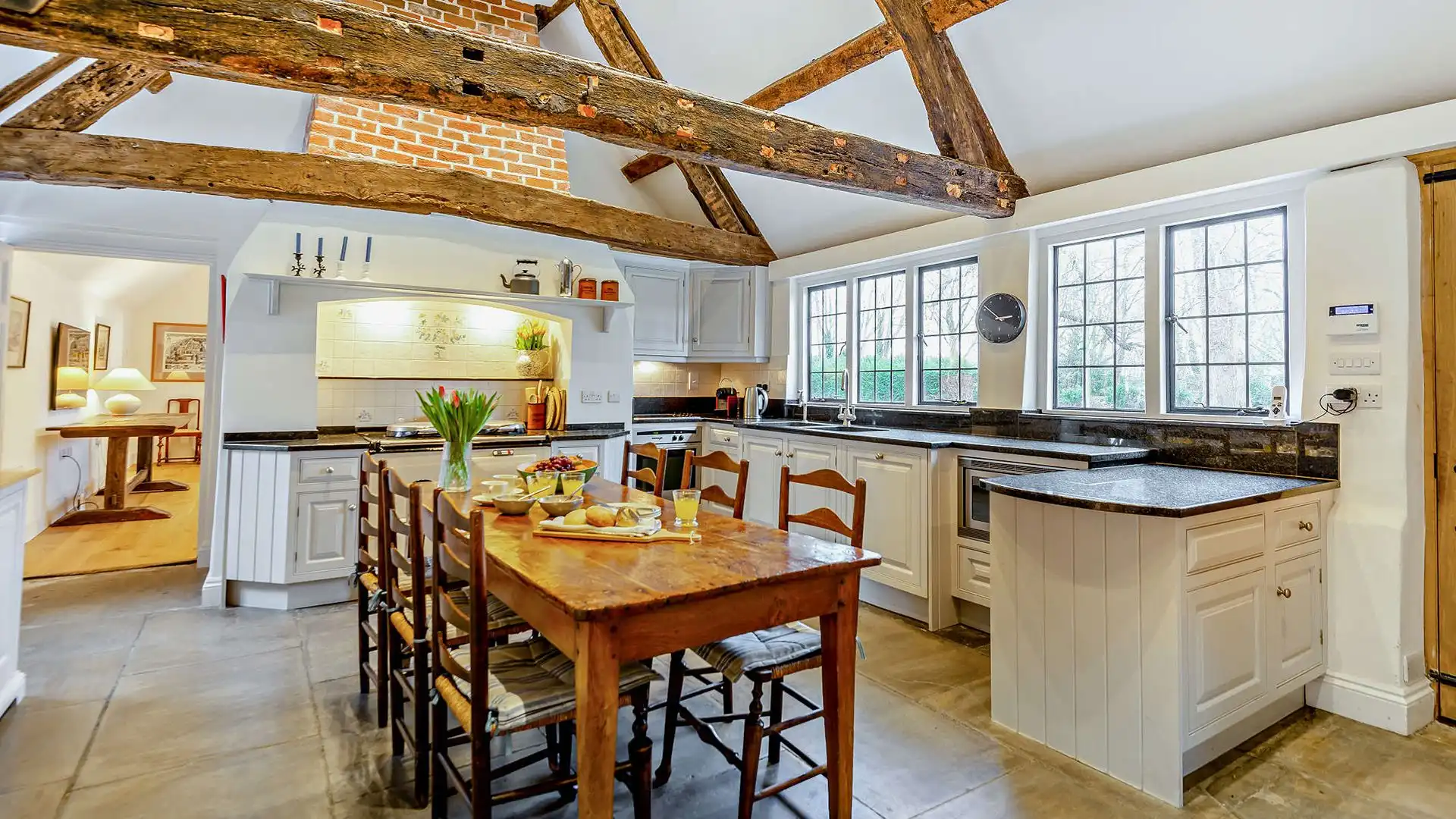 High ceilings with wooden beams and flagstone flooring frame this historic kitchen