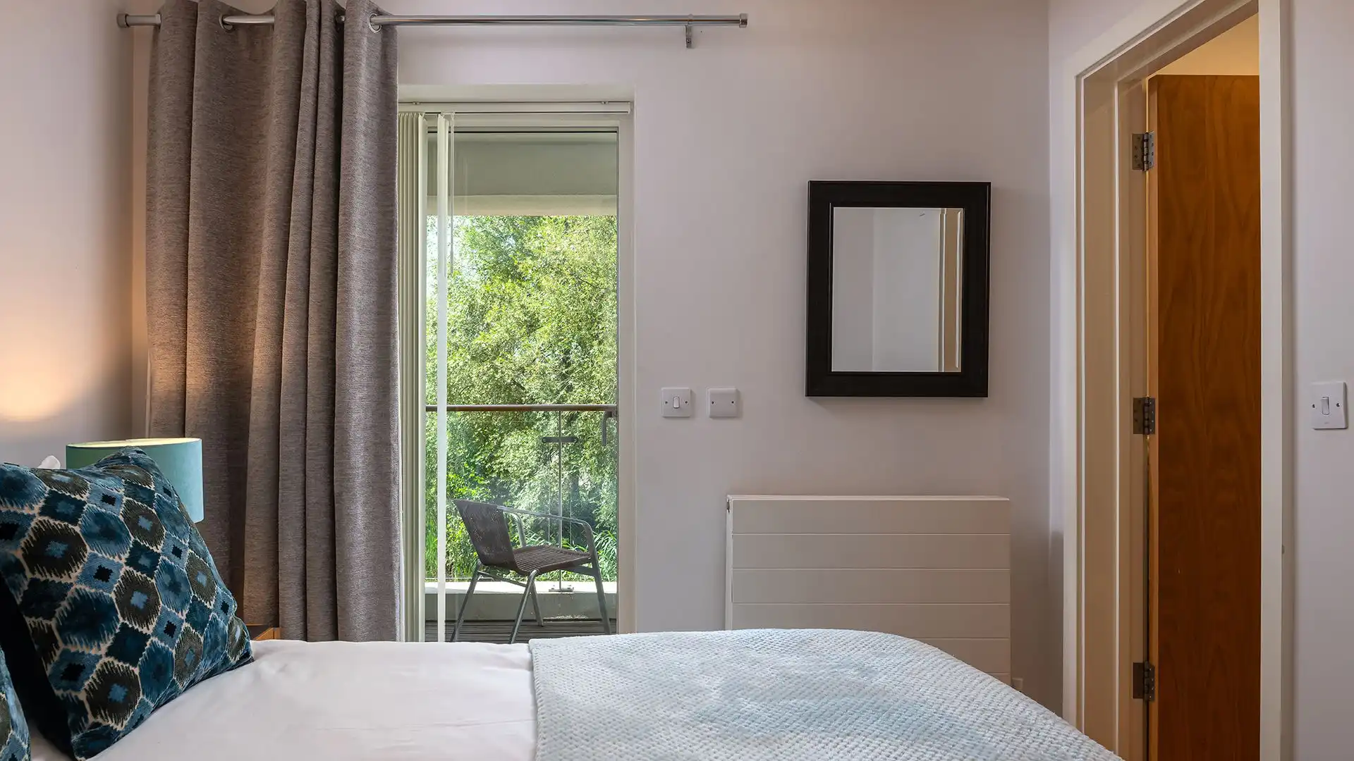 Storage is provided with a built-in wardrobe and there are two bedside tables and lamps