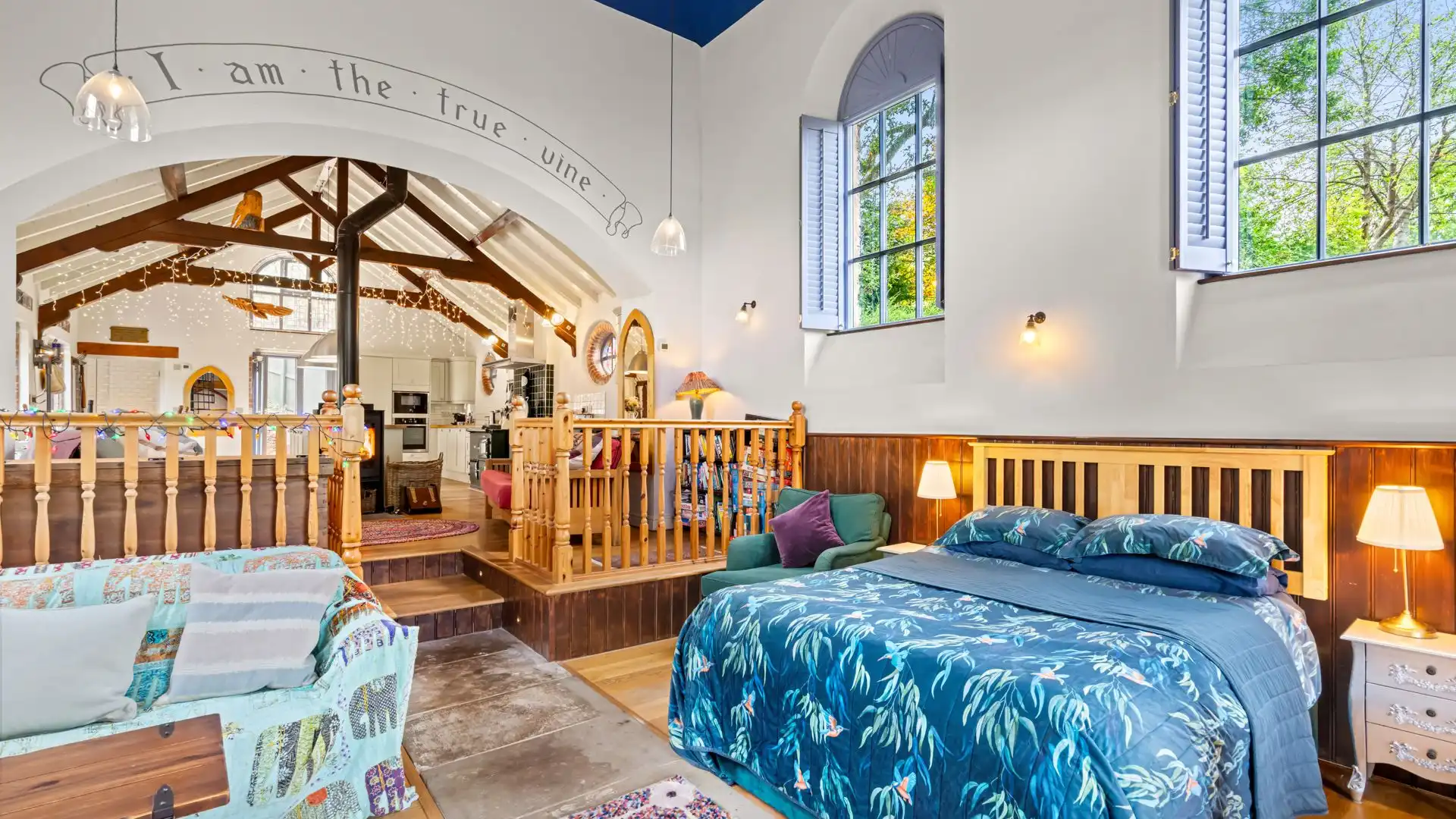 A comfortable double bed is in the middle with bedside tables and a choice of armchairs. 