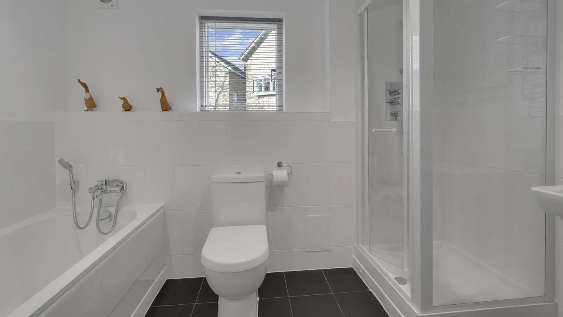 Spacious and bright, the main bathroom has a bath and shower.