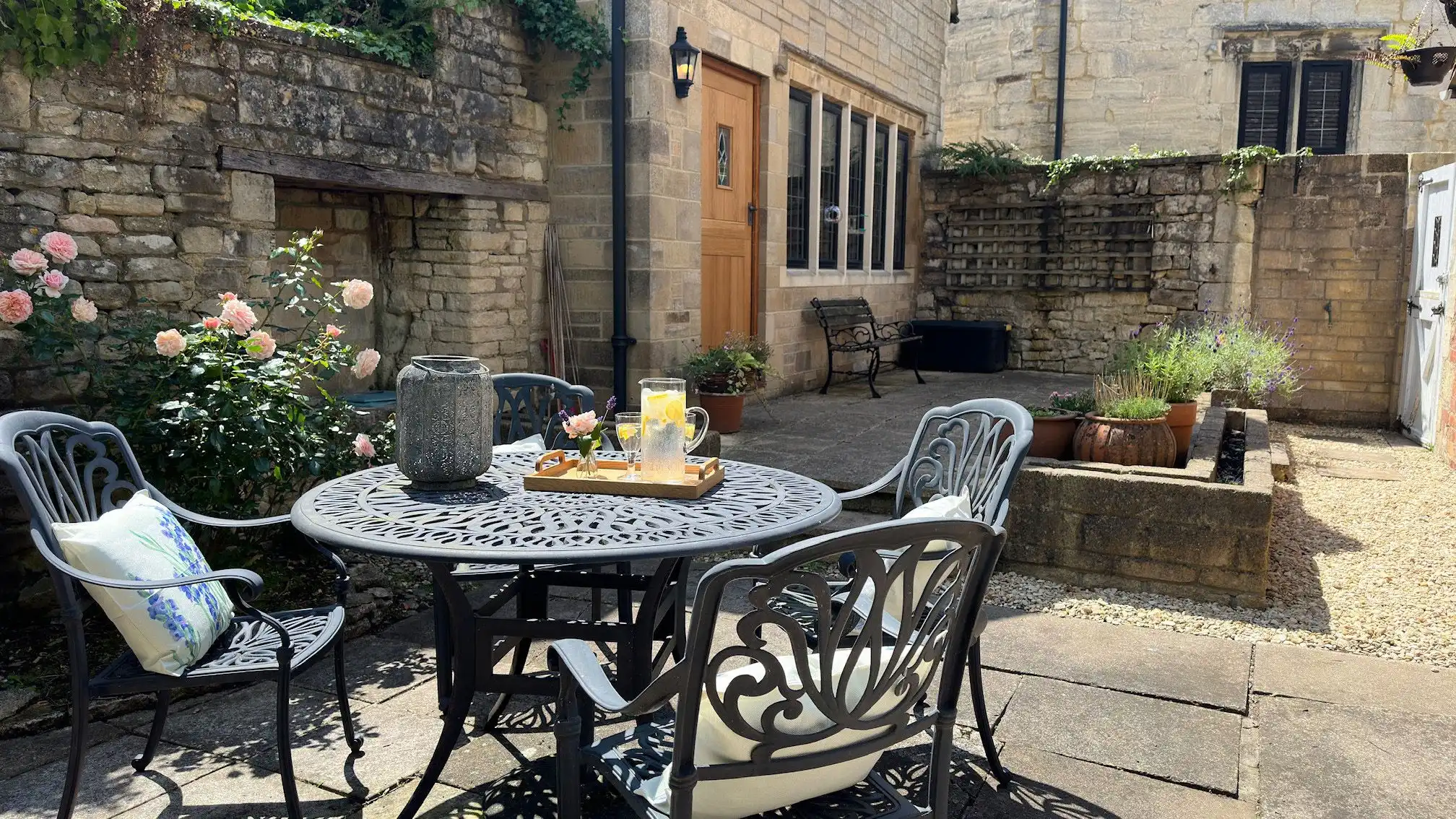 Outside, a pretty courtyard garden is filled with planters and sunlight.