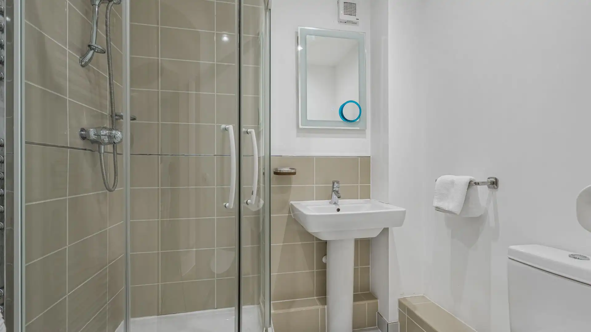 A convenient shower room with shower cubicle, WC, and basin.