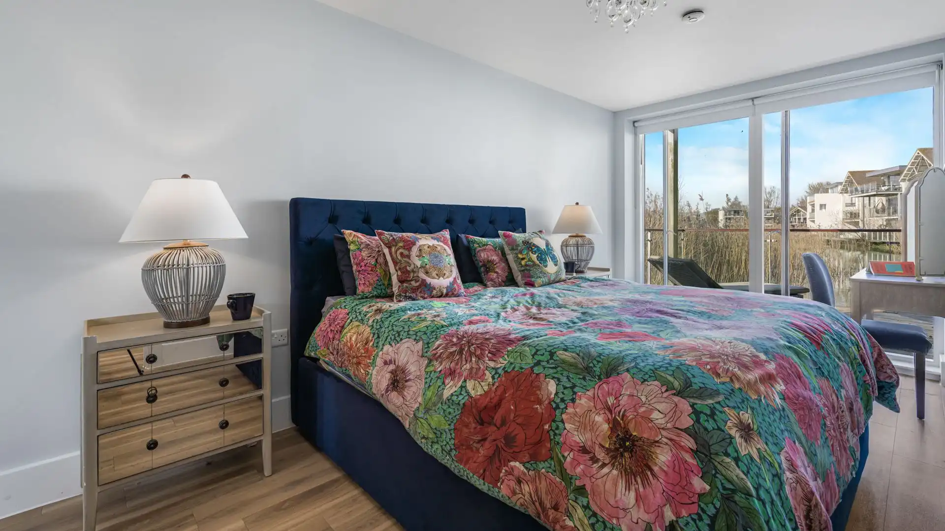 A calming and comfortable bedroom with sliding doors opening onto the decking. 