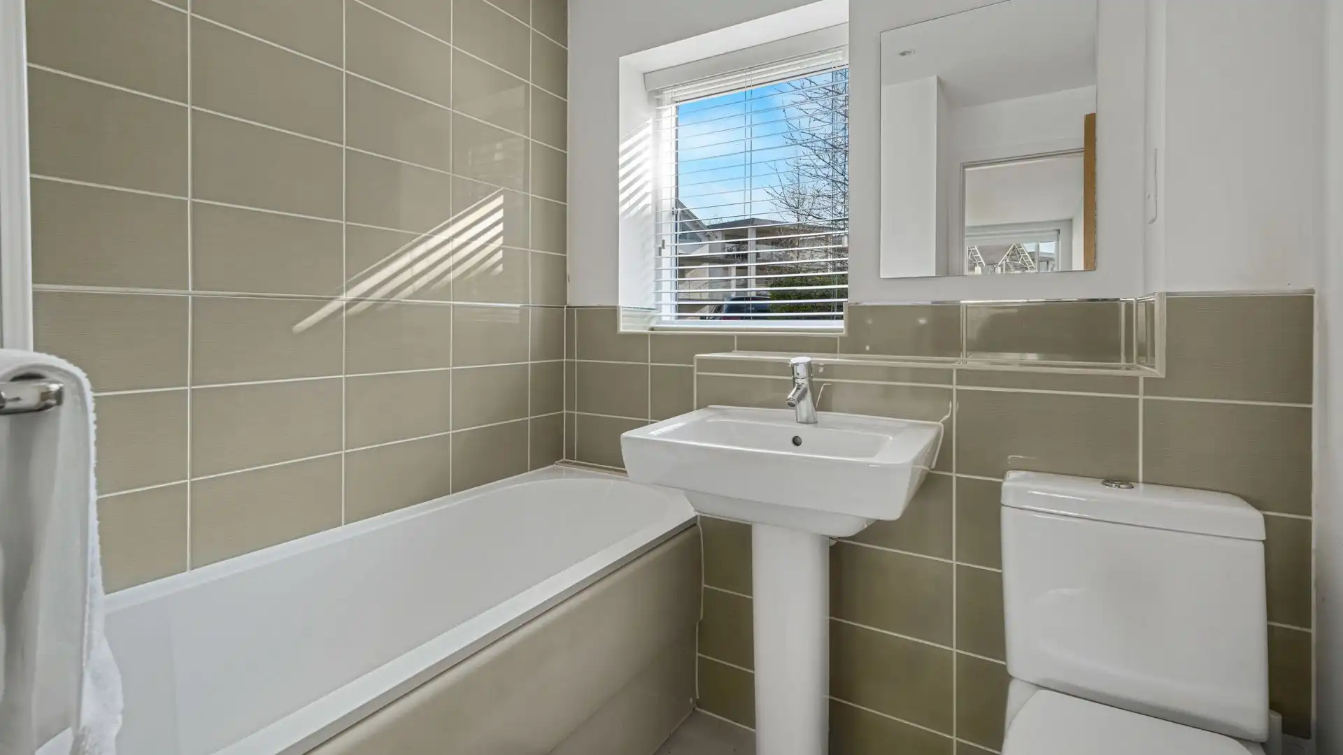 Featuring a bath with shower over, WC, and basin, ideal for a long soak after a day exploring the lakes and trails.