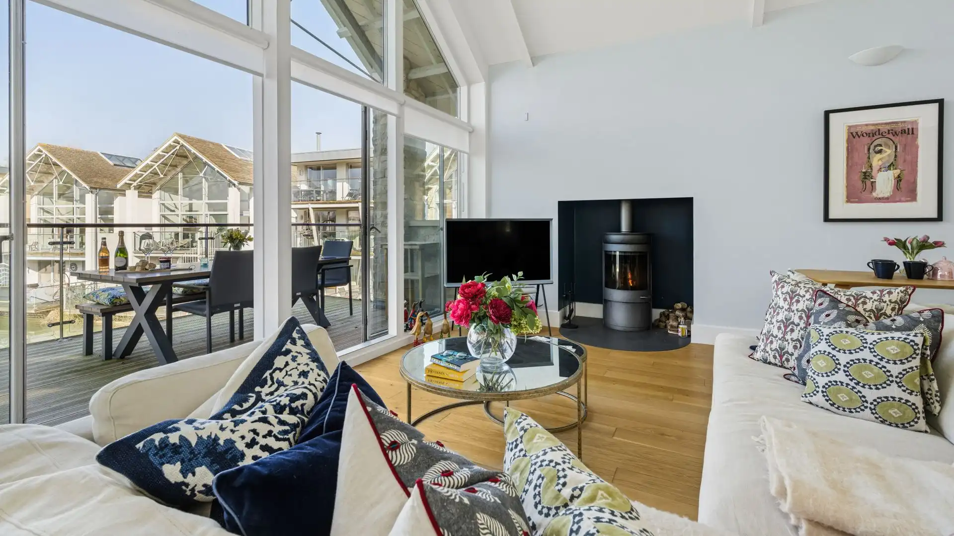 The comfortable living space features a corner sofa, Smart TV, and woodburning stove.