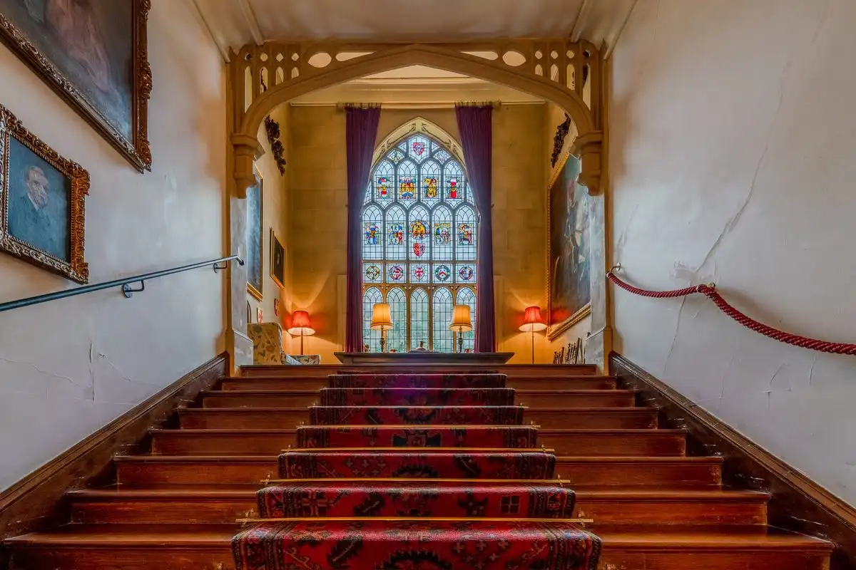 Traitors-style stained glass up to stairs on a historic English estate